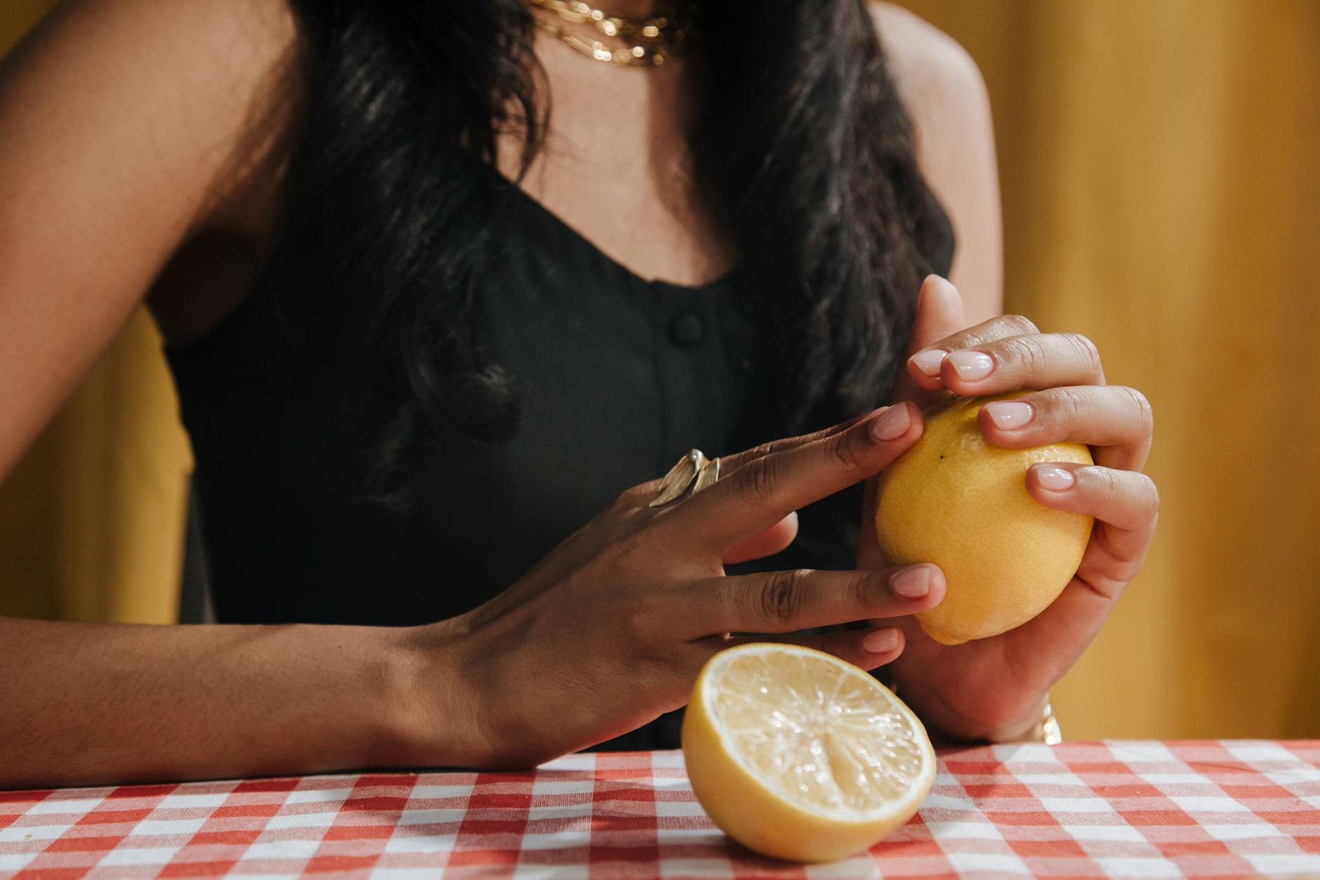 Close-up of a woman holding a fresh lemon, symbolizing the bright, refreshing sensation of lemon vibrators