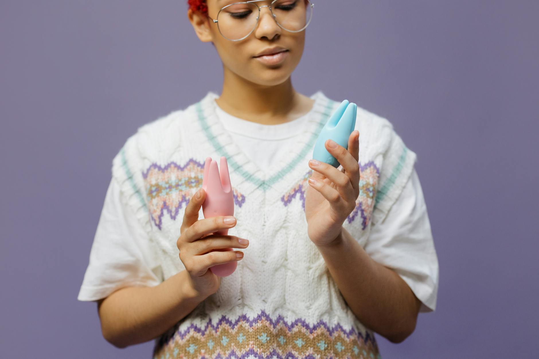 Woman holding a blue vibrator, considering pleasure at midlife.